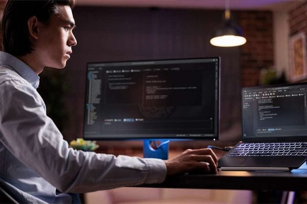 IT professional studying for CompTIA A+, Network+, and Security+ certifications. Man working on computer code.