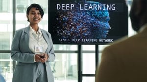 Deep Learning Fundamentals presentation. Woman presenting simple deep learning network.