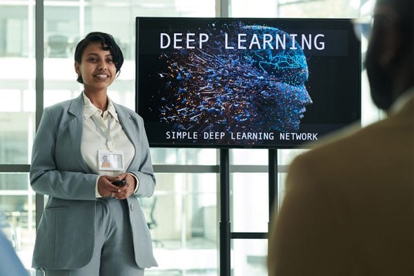 Deep Learning Fundamentals presentation. Woman presenting simple deep learning network.