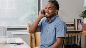 Man on phone. ICB Business Management student works from home. Higher Certificate in Office Administration.