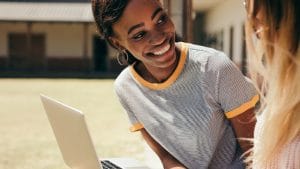 ICB Business Management student smiles with laptop. National Certificate: Small Business Financial Management.