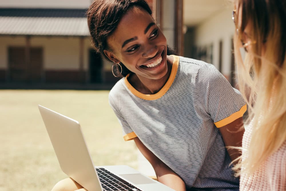 ICB Business Management student smiles with laptop. National Certificate: Small Business Financial Management.
