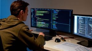 Python Novice to Pythonista: Programmer coding on dual monitors. Learning Python programming.
