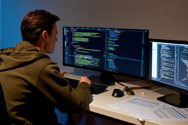 Python Novice to Pythonista: Programmer coding on dual monitors. Learning Python programming.