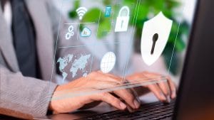 Cyber resilience and risk management. Person typing on laptop with security icons. Data protection and cybersecurity.