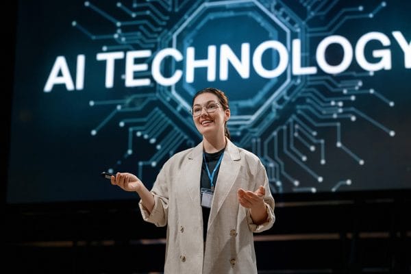 AI technology presentation. Woman presenting machine learning models on stage.