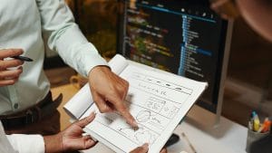 Interactive JavaScript Websites: Web developers designing a website layout. Computer screen with code in the background.