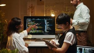 JavaScript Novice to Professional: Team of developers collaborating on code. Software development.