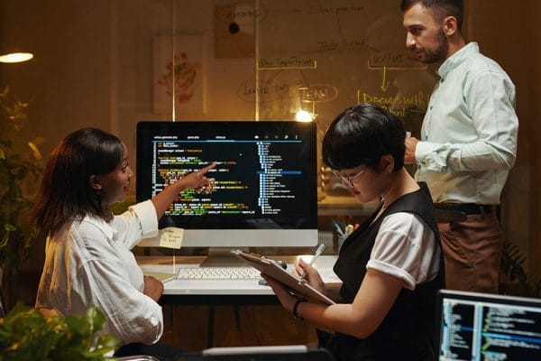 JavaScript Novice to Professional: Team of developers collaborating on code. Software development.