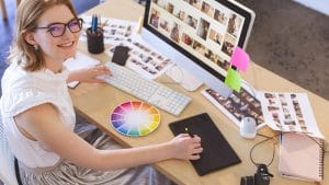 Learn visual design: Woman at desk with computer, color wheel, and graphic tablet. Visual design elements.