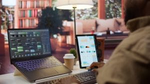 ASP.NET web applications developer working on laptop and tablet. Coding, programming, and software development.