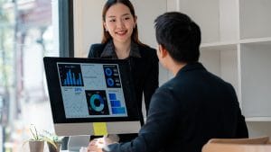 Business Analyst to Data Analyst: Team analyzing data dashboards on a computer screen.