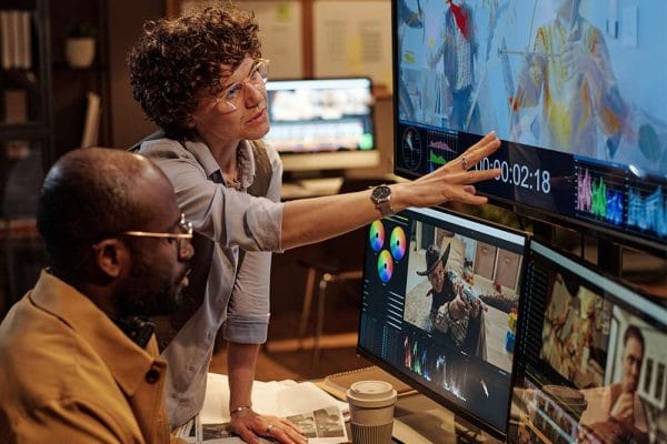 Communications Manager Journey: Team reviewing video editing software.