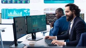 CompTIA Data+ professionals analyzing data on screens. Data analysis, charts, and graphs are visible.