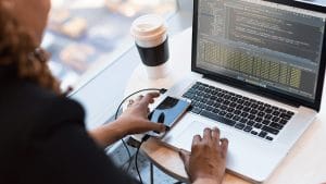 Microsoft DevOps solutions: Developer coding on laptop. Designing & implementing software with AZ-400.