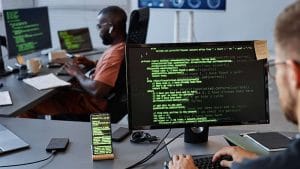 IT Professional at work. Developers coding on computers. Software development, cybersecurity.