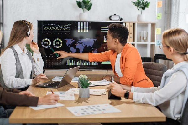 Marketing automation analyst team reviews data on screen. Business meeting.
