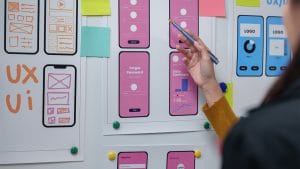 Mobile development: UX/UI designer working on app wireframes and user interface design.