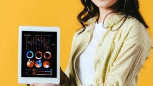 Social Media Strategist journey: Woman holding tablet with data charts. Marketing analytics and strategy.