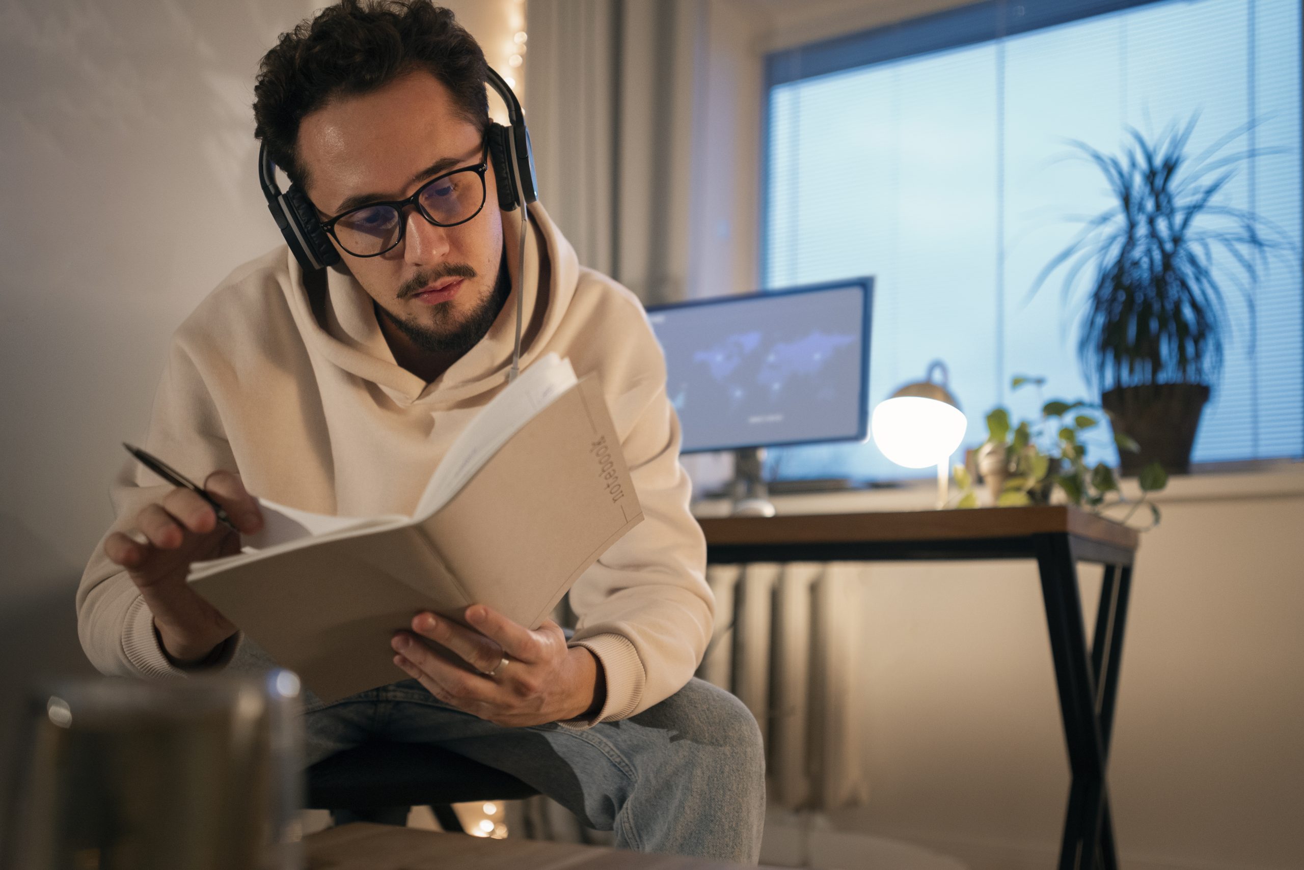AI/Machine Learning student working late at night. Person with headphones studying, taking notes.